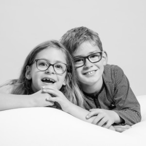 Kinderfoto in schwarz-weiß auf den zwei Geschwister zu sehen sind